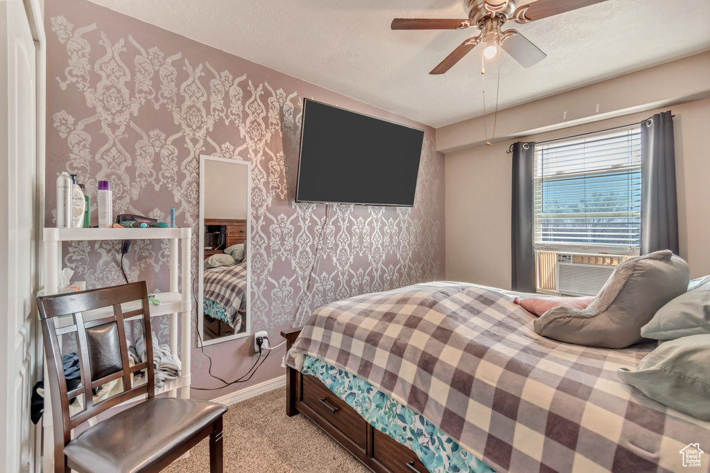 Bedroom featuring wallpapered walls, baseboards, light colored carpet, ceiling fan, and cooling unit