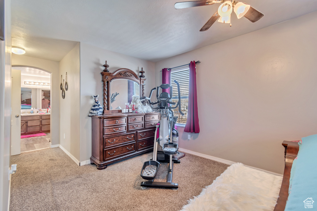 Workout room with arched walkways, carpet flooring, ceiling fan, and baseboards