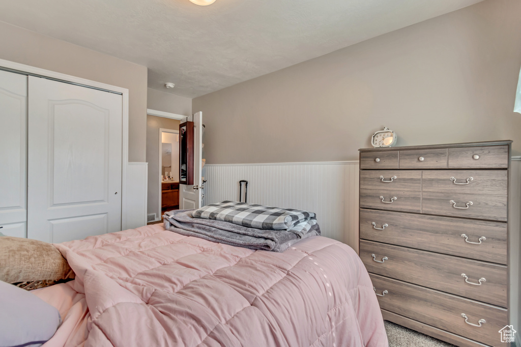 Bedroom with a closet and a wainscoted wall