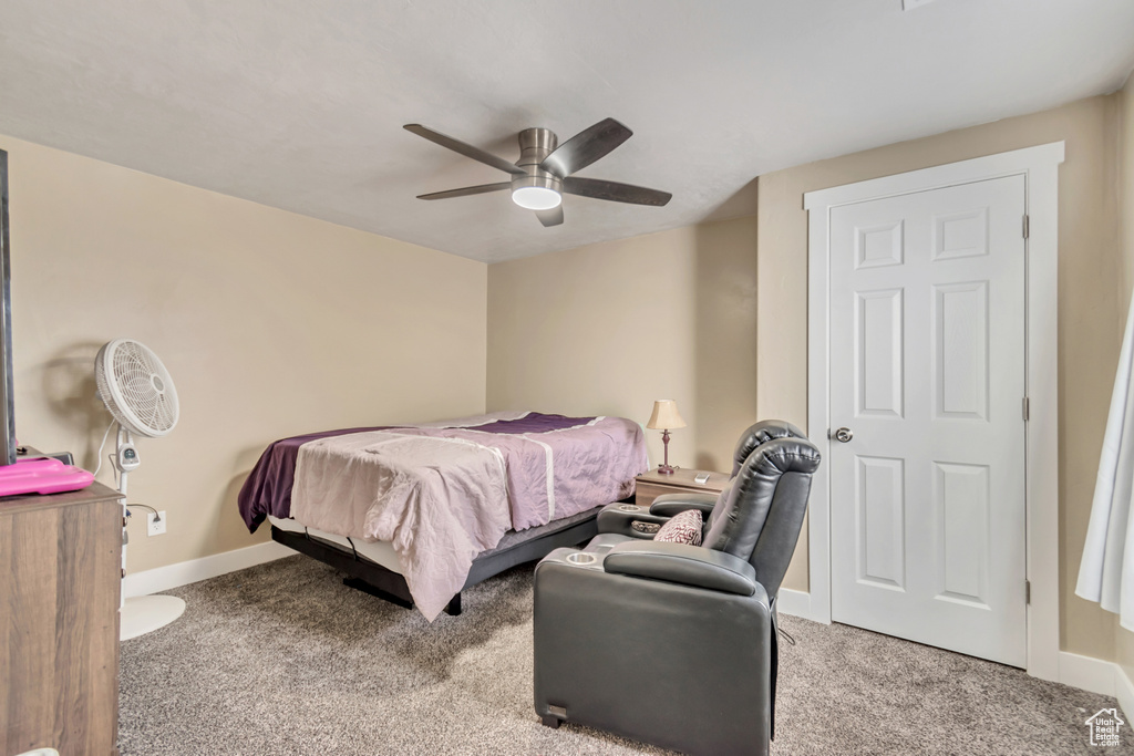 Bedroom with ceiling fan, carpet flooring, and baseboards