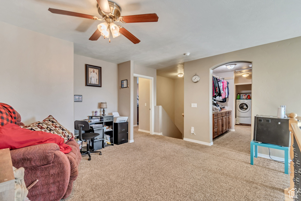 Office space featuring baseboards, arched walkways, a ceiling fan, washer / clothes dryer, and carpet flooring