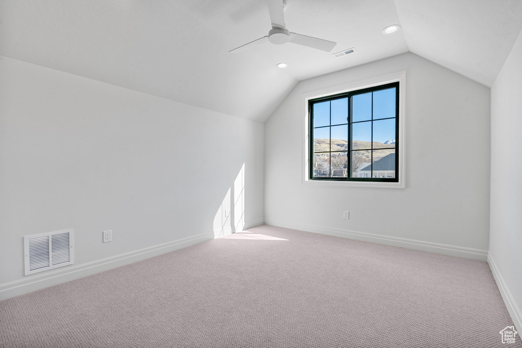 Additional living space with lofted ceiling, carpet floors, baseboards, and visible vents