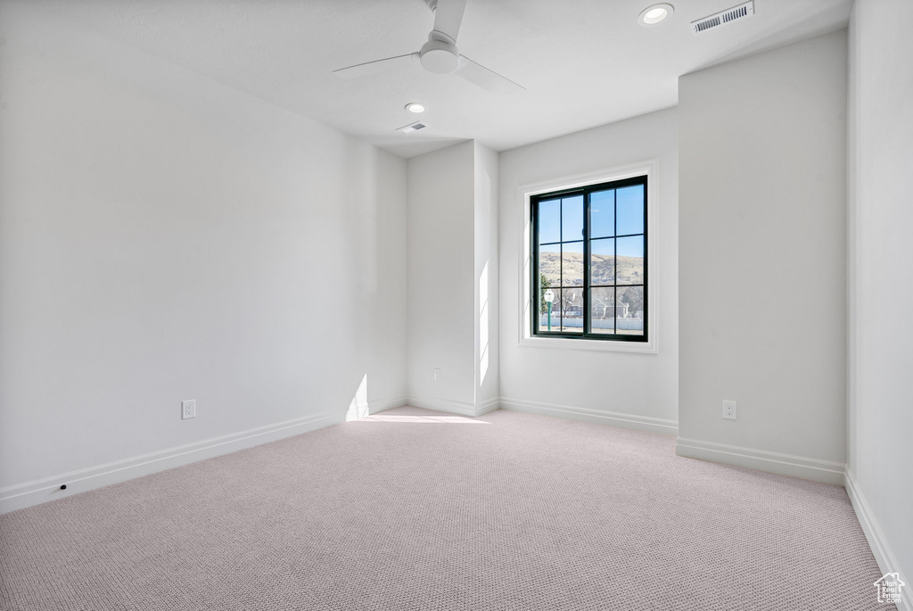 Carpeted spare room with recessed lighting, visible vents, ceiling fan, and baseboards