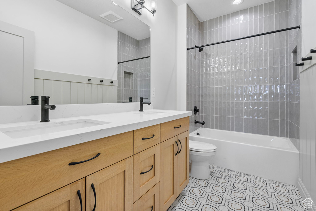 Full bathroom with shower / bath combination, tile patterned flooring, double vanity, and a sink