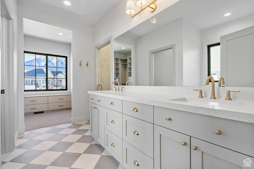 Bathroom with double vanity, recessed lighting, a sink, and tile patterned floors