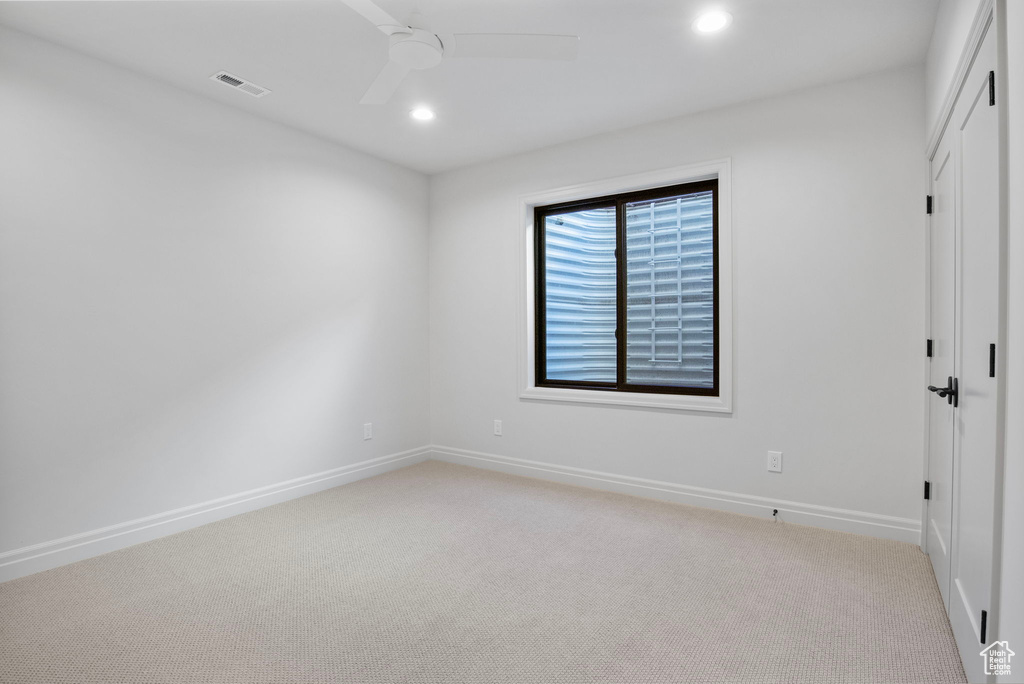 Unfurnished room with recessed lighting, light colored carpet, visible vents, ceiling fan, and baseboards