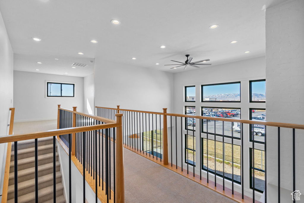 Hallway featuring an upstairs landing, visible vents, and recessed lighting