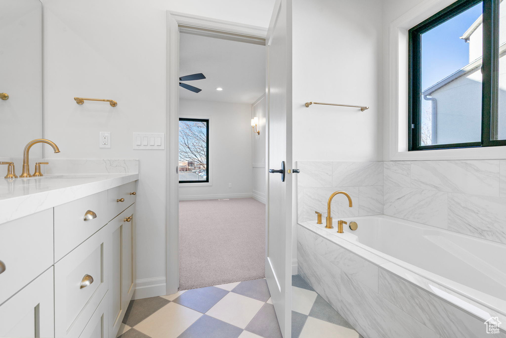 Bathroom with a bath, baseboards, vanity, and tile patterned floors