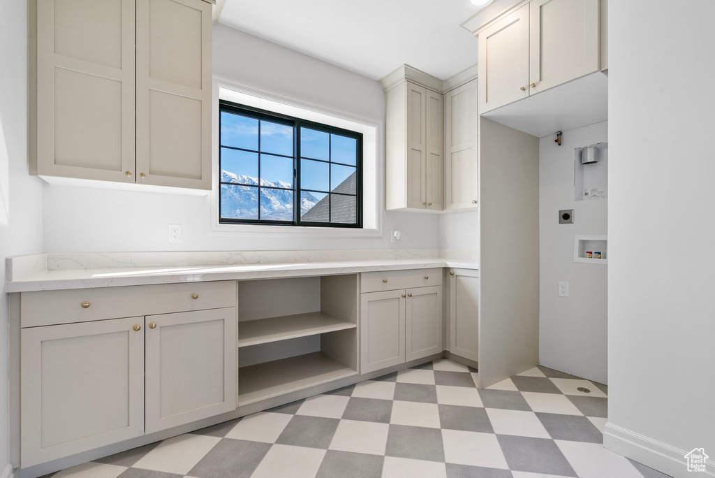 Kitchen with built in study area, light floors, and open shelves