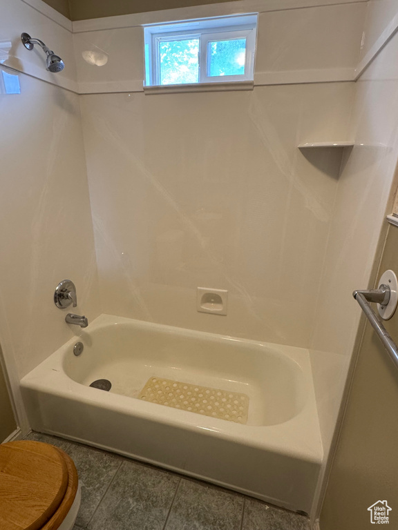 Full bathroom featuring tile patterned flooring and washtub / shower combination