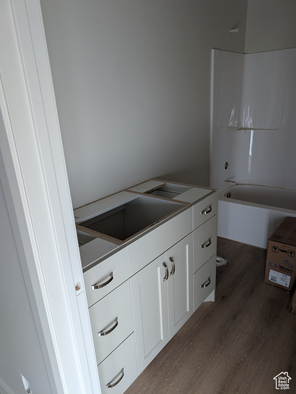 Full bath featuring shower / bathing tub combination, vanity, and wood finished floors