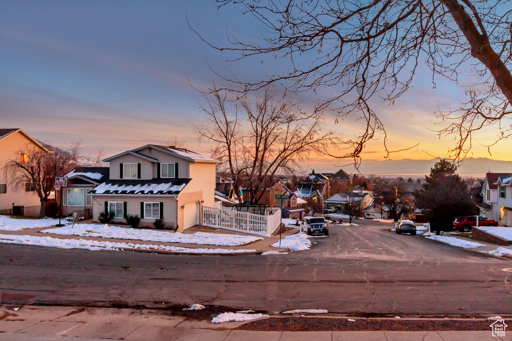 View of front of property with a garage, a residential view, and fence