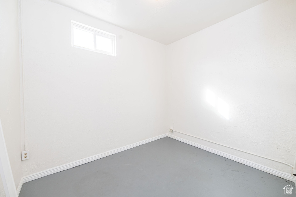 Empty room featuring baseboards and concrete flooring
