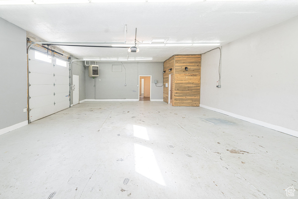 Garage featuring a garage door opener and baseboards