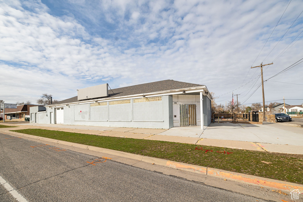 View of side of property with roof with shingles and a fenced front yard