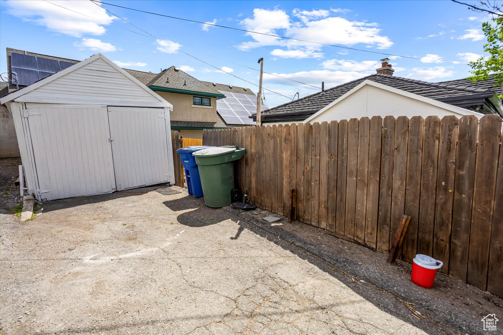 View of patio / terrace featuring fence, an outdoor structure, and a storage unit