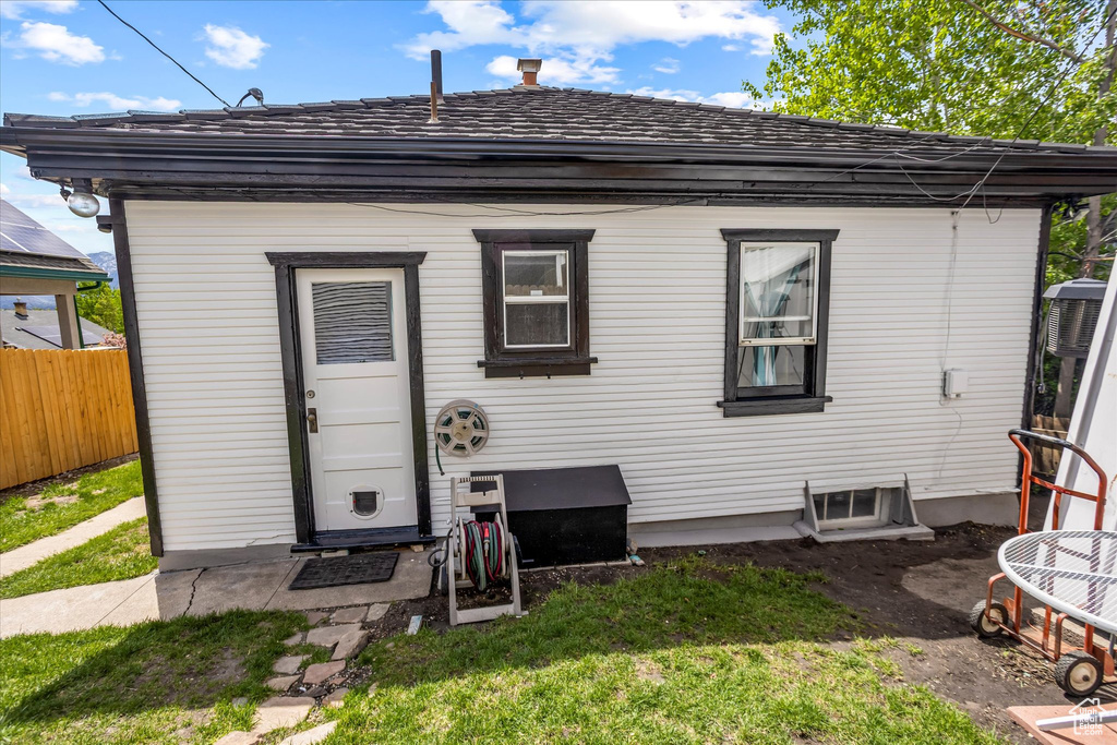 Rear view of property with a yard and fence