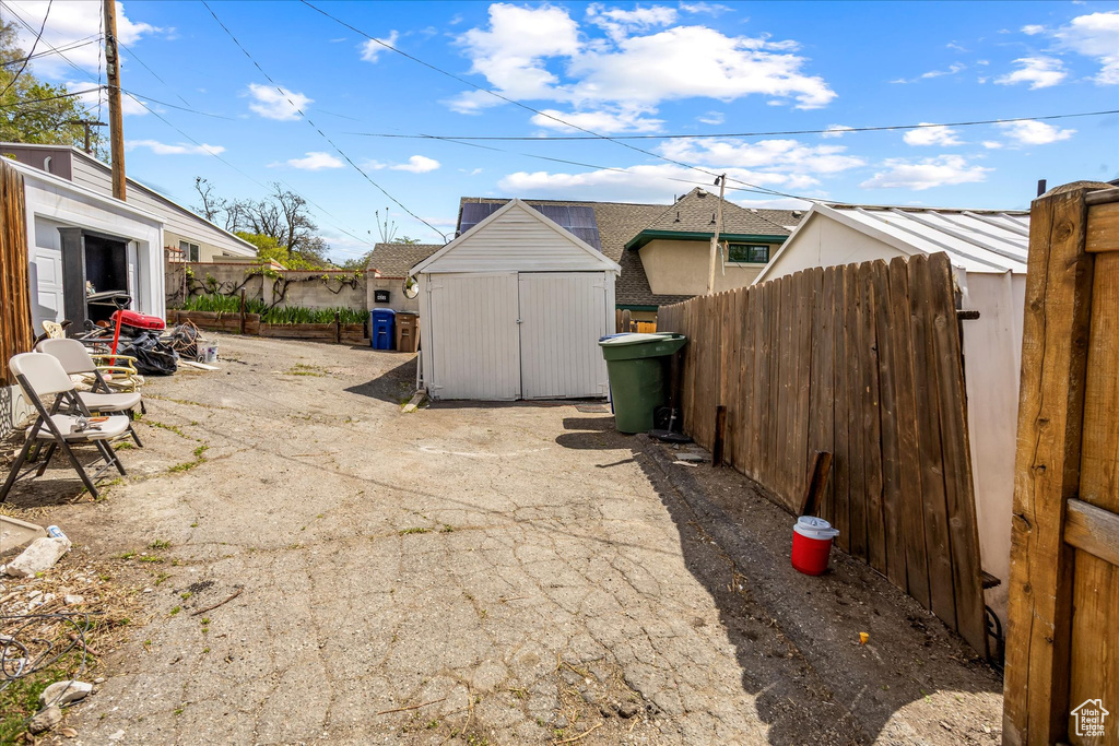 View of patio featuring a shed, an outbuilding, and fence
