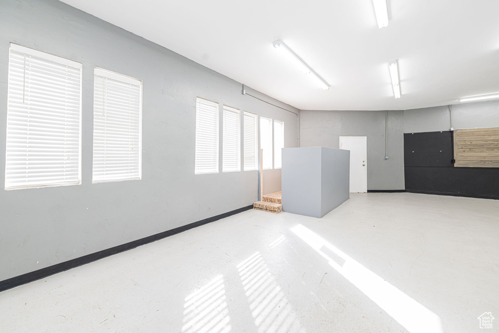 Spare room featuring concrete flooring and baseboards
