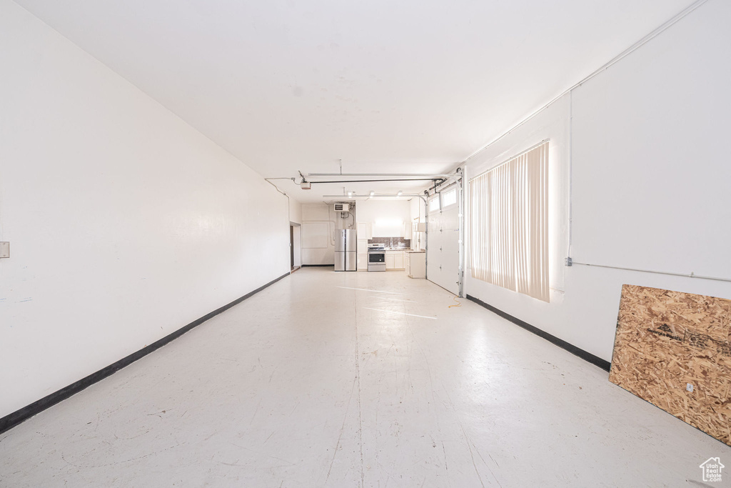 Unfurnished living room with concrete flooring and baseboards