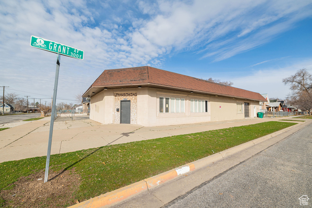 Exterior space featuring a yard, fence, and stucco siding