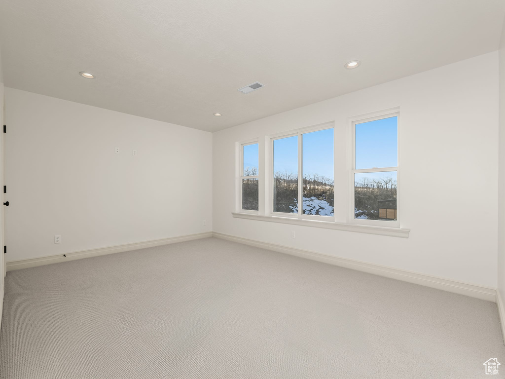 Unfurnished room featuring recessed lighting, baseboards, visible vents, and light colored carpet