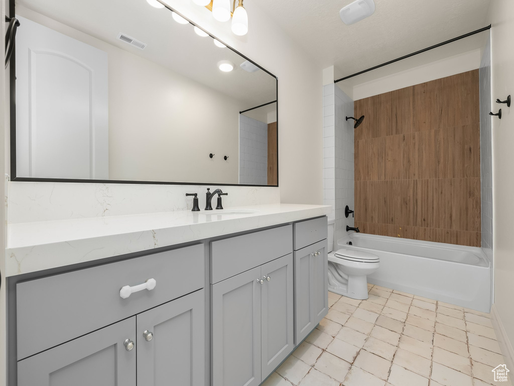 Full bath featuring washtub / shower combination, visible vents, vanity, and toilet