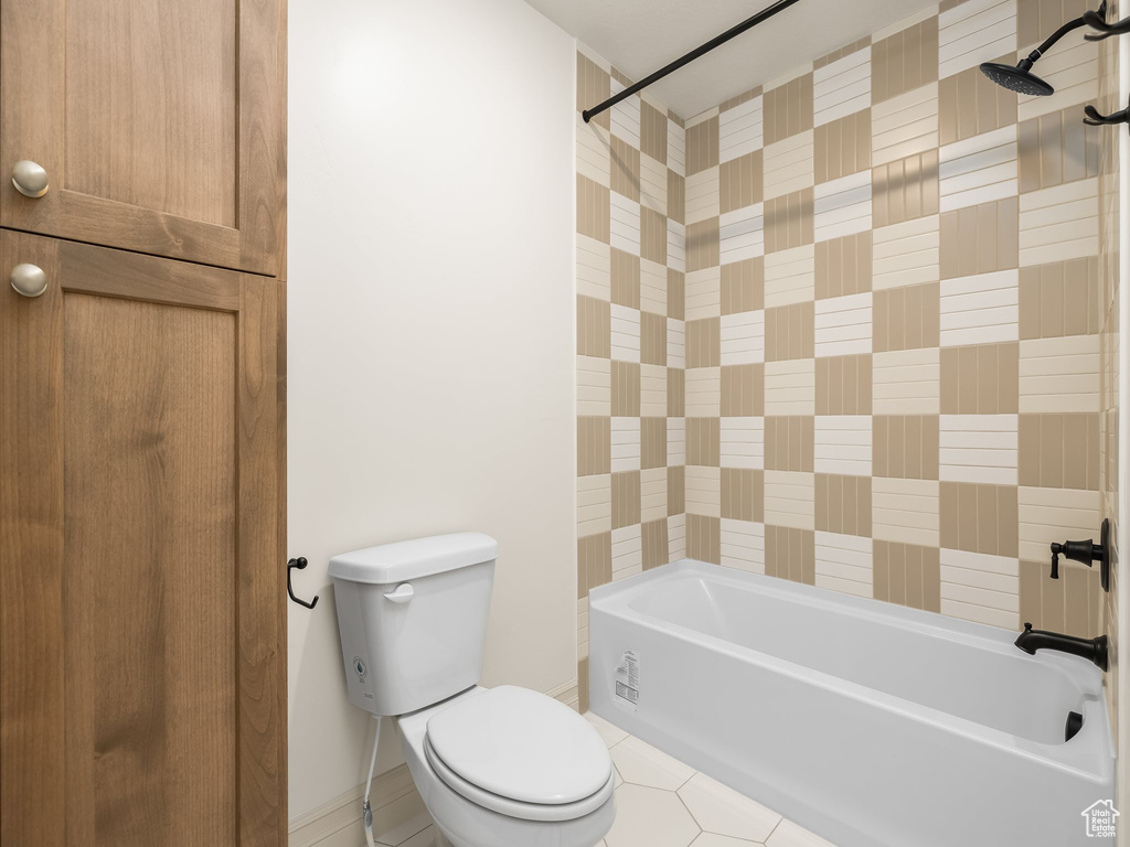 Bathroom featuring shower / bath combination, toilet, and tile patterned floors