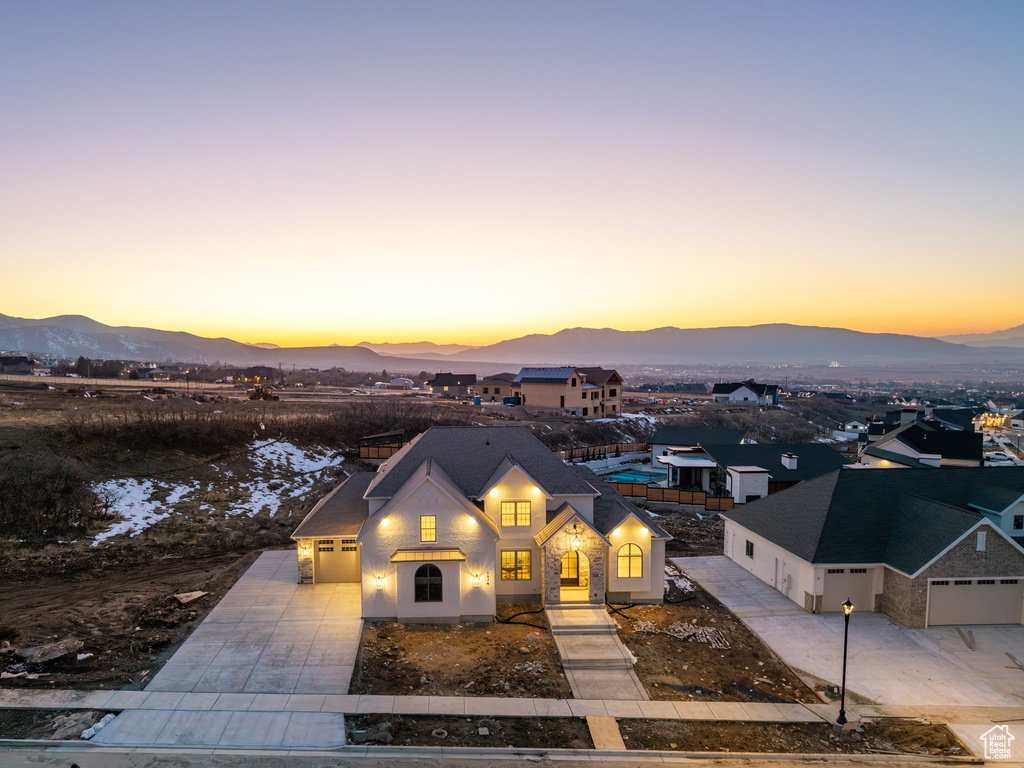 View of front of property with concrete driveway, a mountain view, and an attached garage