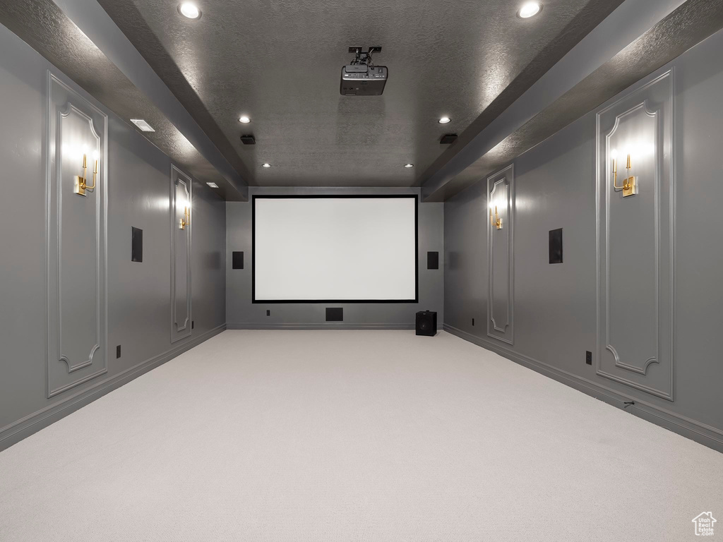 Carpeted cinema featuring recessed lighting, a decorative wall, and a textured ceiling