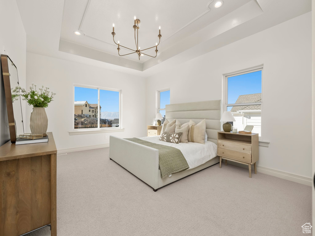 Carpeted bedroom featuring baseboards, a tray ceiling, recessed lighting, and an inviting chandelier