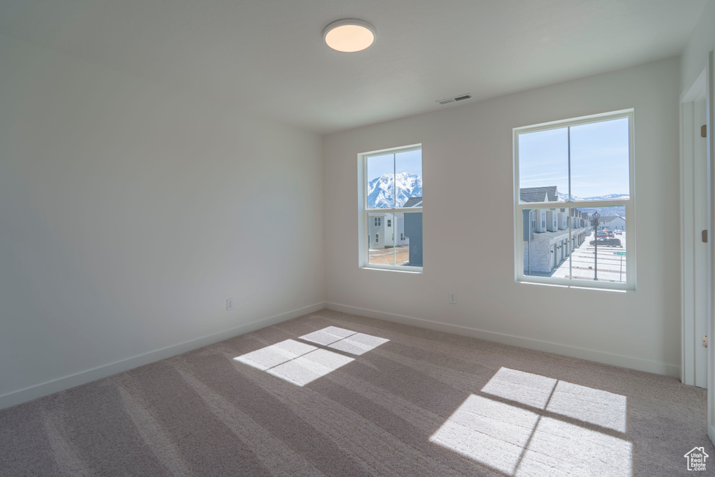 Unfurnished room with light carpet, visible vents, and baseboards