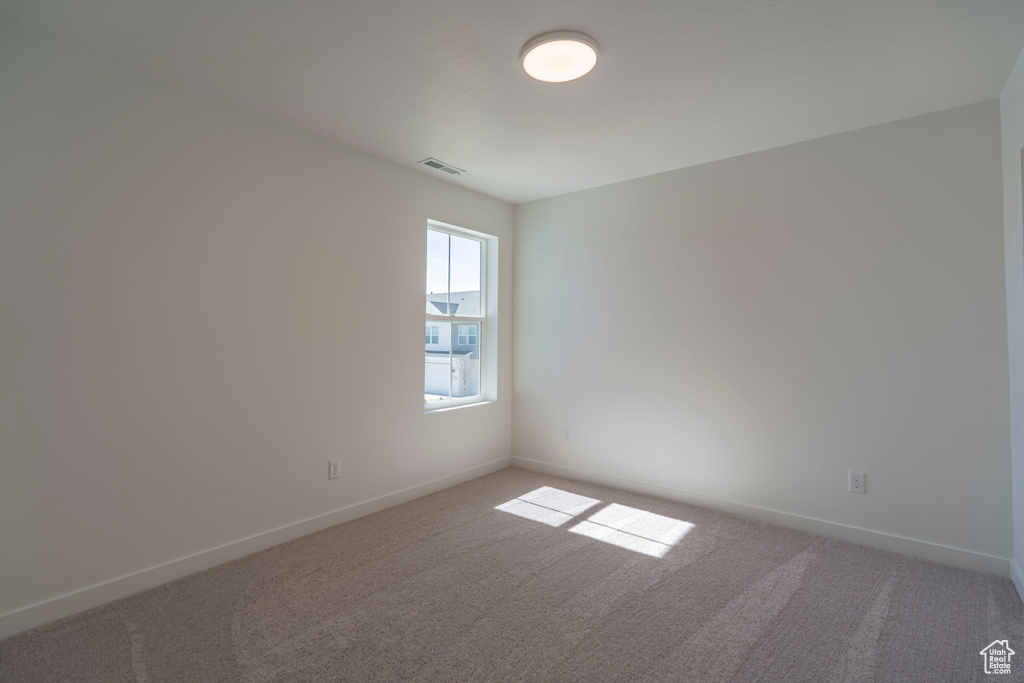 Spare room featuring visible vents, baseboards, and carpet floors