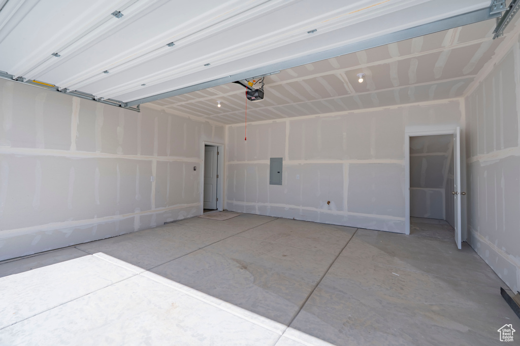 Garage featuring electric panel and a garage door opener