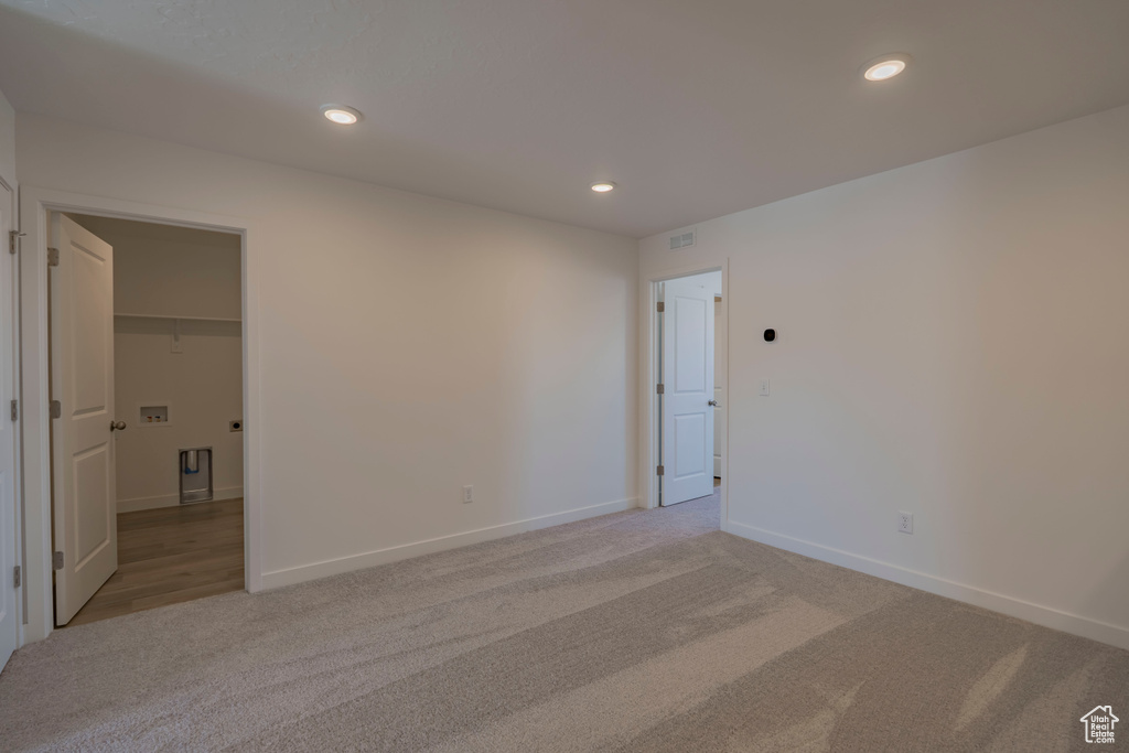 Spare room with recessed lighting, light colored carpet, and baseboards