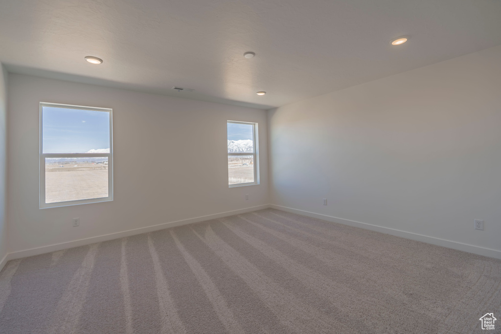 Empty room featuring recessed lighting, baseboards, and light carpet