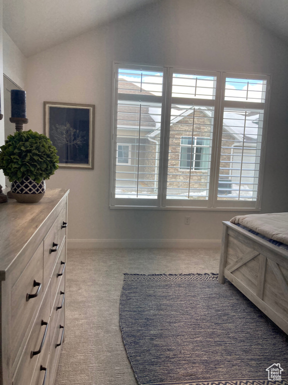 Carpeted bedroom featuring lofted ceiling and baseboards