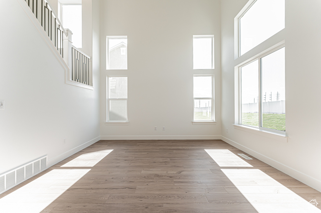 Spare room featuring a towering ceiling and light wood finished floors