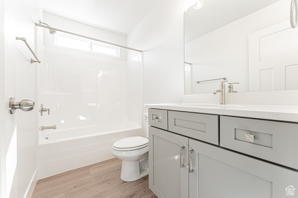 Full bath with wood finished floors, vanity, and shower / tub combination
