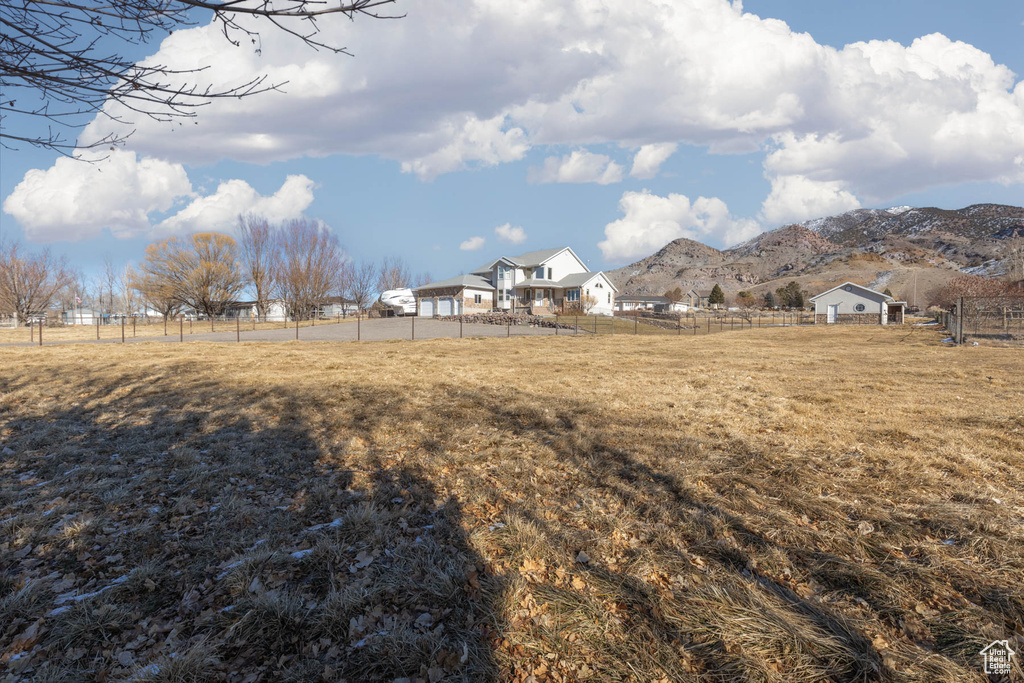 View of yard featuring fence, a mountain view, and a rural view