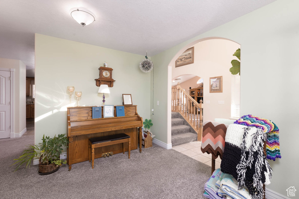 Living area with stairway, carpet, arched walkways, and baseboards