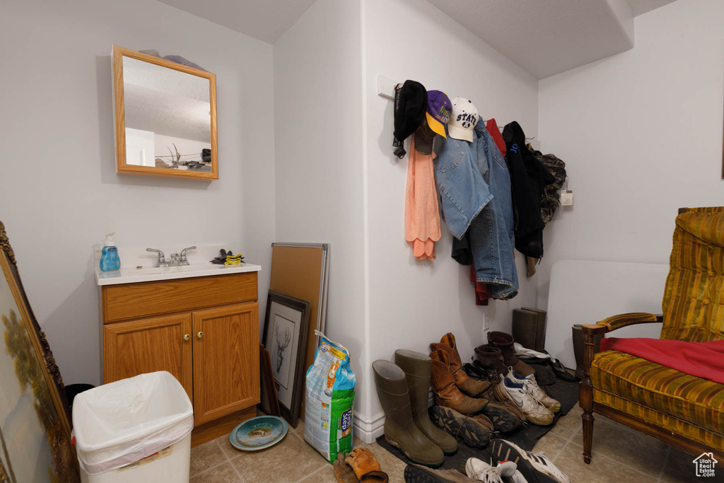 Mudroom with light tile patterned floors and a sink