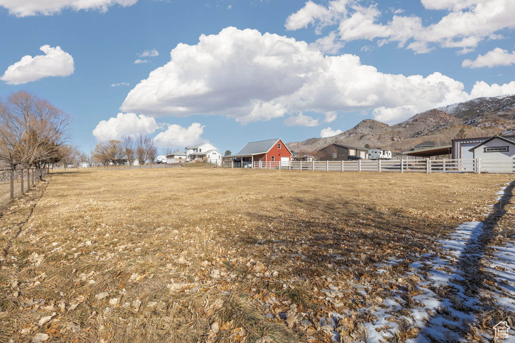 View of yard with fence, a mountain view, and a rural view