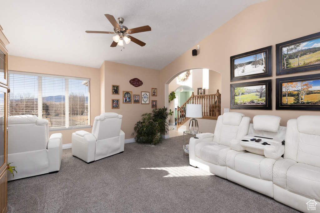 Carpeted living area featuring stairway, arched walkways, lofted ceiling, and baseboards