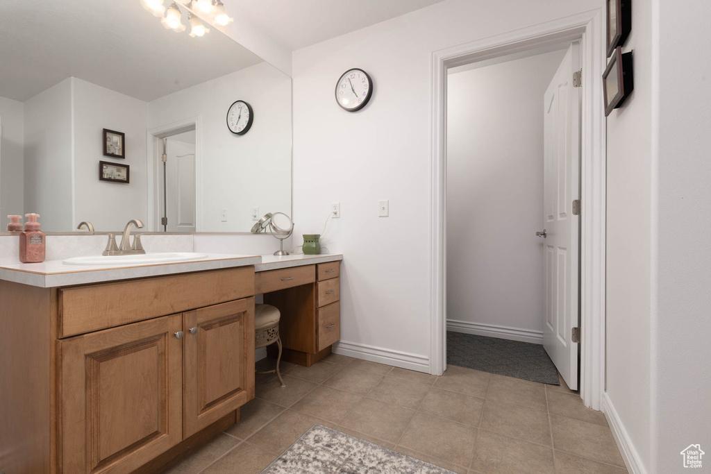 Bathroom with vanity, baseboards, and tile patterned floors