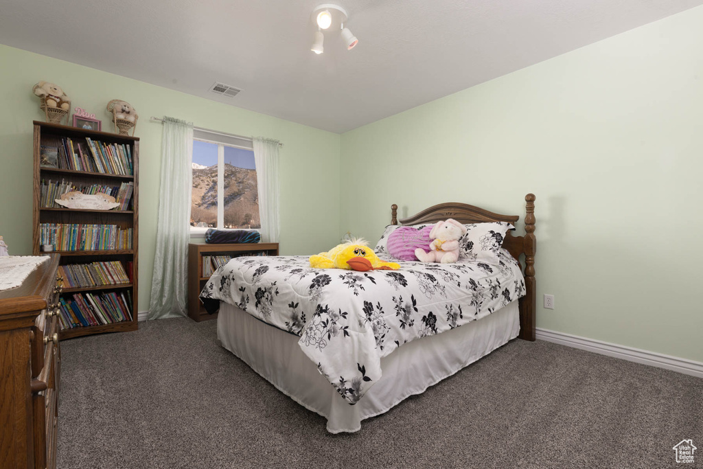 Carpeted bedroom featuring visible vents and baseboards