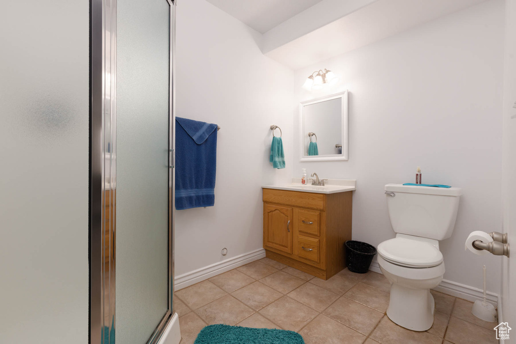 Full bath featuring baseboards, toilet, tile patterned flooring, an enclosed shower, and vanity