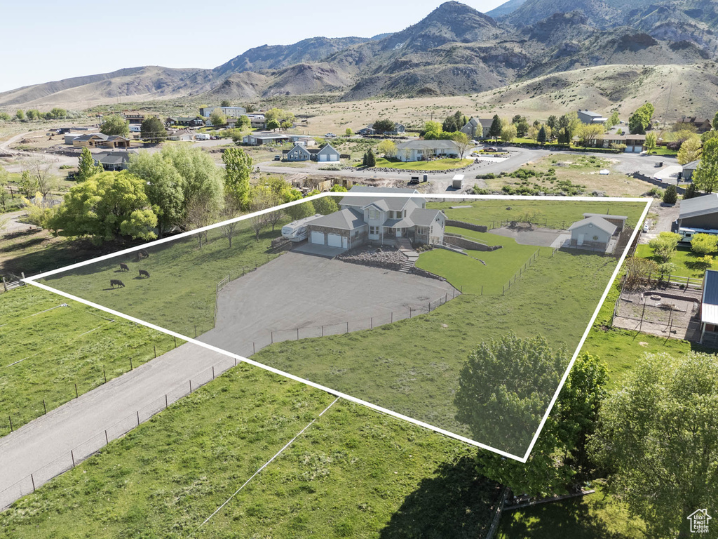 Aerial view of property and surrounding area with property parcel outlined and a mountain backdrop