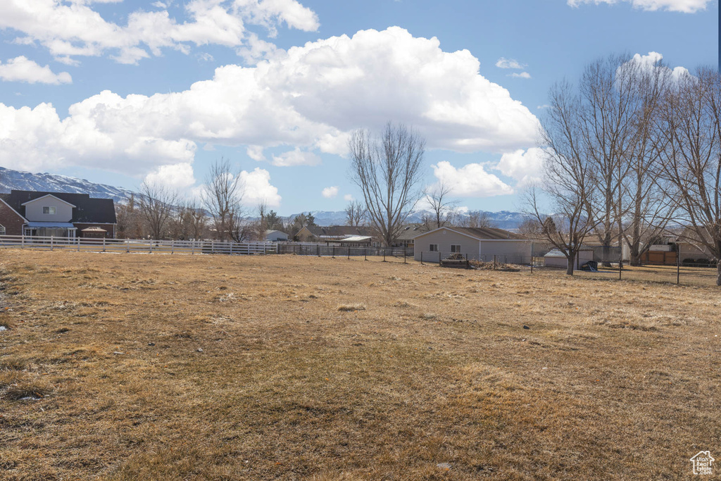 View of yard featuring fence and a rural view