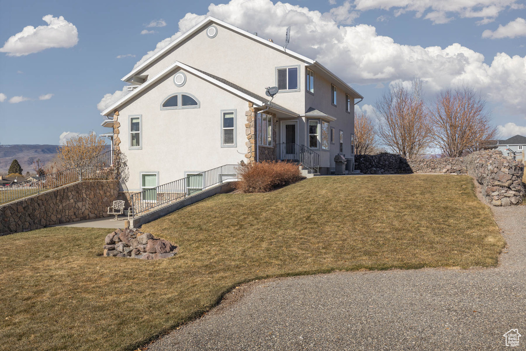 View of property exterior featuring central air condition unit, a yard, and stucco siding